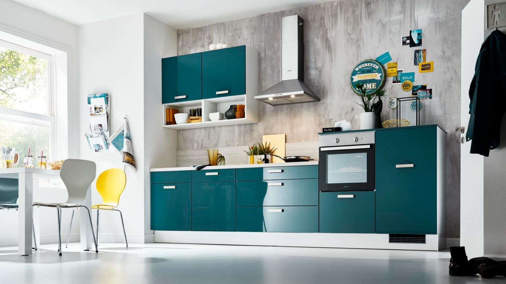 Moderne Küche in Petrolblau mit Hängeschränken, Backofen und Dunstabzugshaube – stilvolle Lösung für größere Räume.