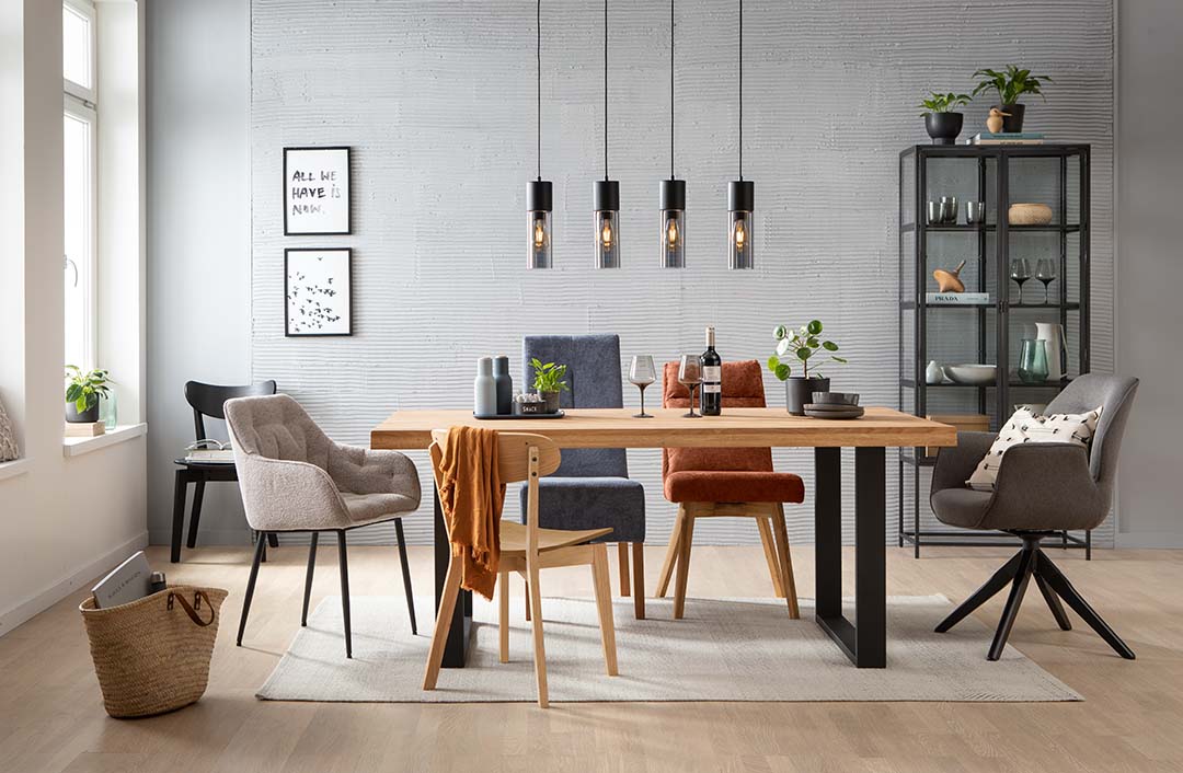 In einem WG-Esszimmer mit holzfarbenem Tisch bietet das Kombinieren von Stühlen in Farben wie Grau und kühlem Blau zu warm kontrastierendem Orange Ausdrucksmöglichkeiten für alle