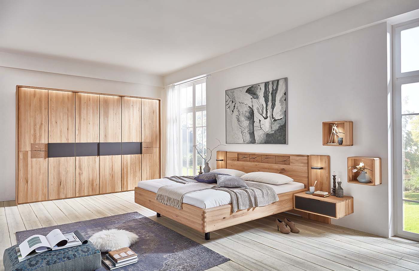 Schwarze Akzentflächen verleihen Bett und Schrank in Holzinspirierten Farben einen modernen Touch