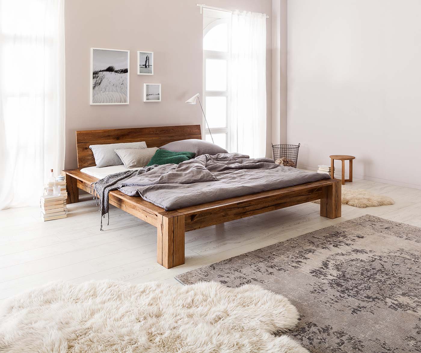 Ein holzfarbenes Bett in robuster Optik sorgt für ein heimeliges Ambiente. Ergänzt mit im Schlafzimmer verteilten Kunstfellen bringt es einen Hauch von Chalet-Stil in Dein Zuhause