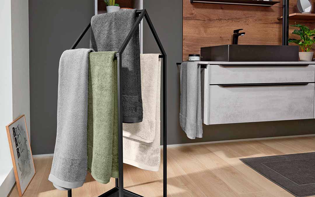 Ein hausförmiger Handtuchhalter aus schwarzer Rahmenkonstruktion unterstreicht den Industrial-Style Deines Badezimmers ebenso wie ein Waschbeckenunterschrank in schwebender Betonoptik