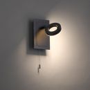 Moderne LED-Wandleuchte in Schwarz mit rundem, schwenkbarem Leuchtkopf und Zugschalter an grauer Wand.