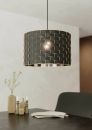 Moderne schwarze Pendelleuchte mit goldenen Akzenten über Esstisch, stilvolle Dekoration im Hintergrund.