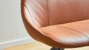 Detailaufnahme eines modernen, braunen Ledersessels mit glatter Oberfläche und elegantem, zeitlosem Design.