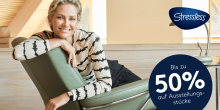 Frau mit blondem, kurzen Haar lächelt entspannt auf einem grünen Stressless-Sessel, daneben ein blauer Kreis mit weisser Schrift „Bis zu 50% auf Ausstellungsstücke“ und Stressless-Logo oben rechts, helle und moderne Umgebung im Hintergrund.
