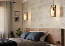 Modernes Schlafzimmer mit Holzbett, blauen Kissen, Hängelampen, Pflanzen und stilvoller Wanddekoration.