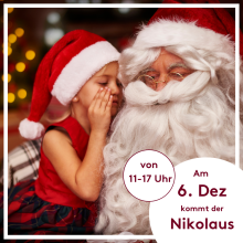 Kleines Mädchen flüstert Nikolaus ins Ohr, beide tragen rote Mützen, weihnachtliche Dekoration im Hintergrund.