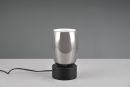 Moderne silberne Tischlampe mit glu00e4nzendem Metallfuu00df auf weiu00dfem Tisch vor grauem Hintergrund, Designlampe.