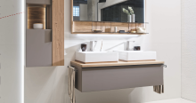 Modernes Badezimmer mit Doppelwaschbecken, Holzdetails, Spiegel, Handtuch und stilvoller Dekoration.