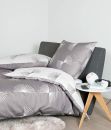 Graue Bettwäsche mit weißem, modernem Fächer-Muster auf Bett, Nachttisch mit Lampe und Smartphone im Schlafzimmer.