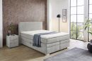 Modernes Boxspringbett in Grau mit Nachttisch, Holzboden, großer Fensterfront und stilvoller Tapete im Schlafzimmer.
