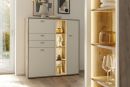 Moderne Kommode mit LED-Beleuchtung, weißen Fronten, Holzdekor und dekorativen Accessoires im Wohnzimmer.