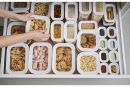 Vorratsbehälter mit Pasta, Keksen, Popcorn und Trockenwaren ordentlich in einer Schublade sortiert.