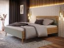Modernes Bettgestell aus Holz und grünem Stoff, mit gepolstertem Kopfteil und minimalistischem Design.