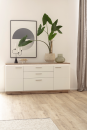 Moderne Kommode mit Dekoration, großer Zimmerpflanze, Kerzenhalter und abstraktem Wandbild im Wohnzimmer.
