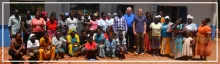 Gruppenfoto mit Franz Rieger vor einem Gebäude mit Schild „Women Empowerment Tailoring School“ 