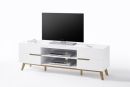 Weißes TV-Lowboard mit Holzfüßen, Flachbildfernseher, Kopfhörer und Elektronikgeräten auf weißem Hintergrund.