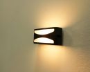 Moderne LED-Wandleuchte mit warmweißem Licht, schwarzes Gehäuse, indirekte Beleuchtung an weißer Wand.