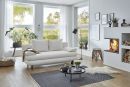 Modernes Wohnzimmer mit weißem Sofa, Kamin, großen Fenstern, Pflanzen und stilvoller Dekoration bei Tageslicht.