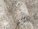 Moderner Teppich mit abstraktem Muster in Grau, Beige und Gold, Nahaufnahme der hochwertigen Textur.