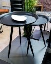 Zwei moderne, schwarze Beistelltische mit schmalen Beinen und weißer Schale, Indoor-Design, Loft-Stil.