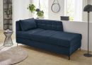 Schlafsofa Marie Blau Modernes, dunkelblaues Sofa mit Kissen im hellen Wohnzimmer, Holzboden, Pflanzen und stilvoller Dekoration.