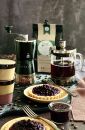 Frisch gebrühter Kaffee, Kaffeebohnen, French Press, Tassen und Blaubeertarte auf rustikalem Holztisch.