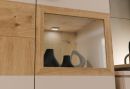 Holzvitrine mit LED-Beleuchtung, modernen schwarzen und weiu00dfen Deko-Vasen, stilvolle Ku00fccheneinrichtung.