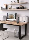 Moderner Schreibtisch mit Computer, Büromaterial, Pflanzen und Wandregalen in einem hellen Home-Office.