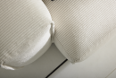 Nahaufnahme eines beigen Cordsofas mit feiner Rippenstruktur auf hellen Fliesen, modernes Wohnzimmermöbel.