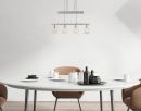 Moderner Essbereich mit rundem weißen Tisch, braunen Stühlen und stilvoller Hängelampe, minimalistisches Design.