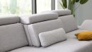 Modernes graues Sofa mit verstellbaren Kopfstützen, gelbem Kissen und Pflanzen im hellen Wohnzimmer.