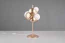 Moderne goldene Tischlampe mit runden Kugeln auf weißem Tisch vor grauem Hintergrund, Design-Lampe Wohnzimmer.