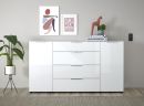 Weiße Kommode mit Schubladen, Deko, Pflanzen, moderner Kunst und Büchern vor grauer Wand im Wohnzimmer.