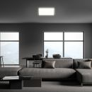 Modernes Wohnzimmer mit grauem Sofa, großen Fenstern, Bergblick, Esstisch und minimalistischer Einrichtung.