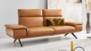 Modernes Ledersofa in Braun mit grünen Zierkissen, stilvolles Wohnzimmermöbel auf schwarzen Metallfüßen.
