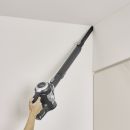 Handstaubsauger mit langem Aufsatz reinigt effizient eine Zimmerecke an der Decke, Staubsauger Reinigung Haushalt.
