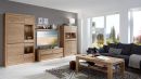 Modernes Wohnzimmer mit Holzmöbeln, grauem Sofa, Couchtisch, TV und großen Fenstern mit Tageslicht.