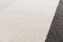 Nahaufnahme eines modernen Teppichs mit cremefarbenen und grauen Streifen, weiche Textur, Wohnzimmer-Dekor.
