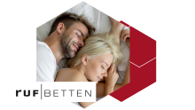 erliebtes Paar schläft entspannt in einem ruf|BETT – für traumhaften Komfort und stilvolles Schlafzimmerambiente
