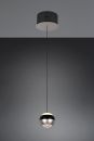 Moderne, runde Pendelleuchte aus Metall mit schwarzem Kabel vor grauem Hintergrund, minimalistisch beleuchtet.