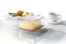 Frische Butter in einer transparenten Butterdose aus Glas auf einem Edelstahlteller, Lebensmittel, Küche.