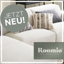 Helles, modernes Ecksofa mit dekorativen Kissen in stilvollem Wohnzimmer, links oben Kreis mit „Jetzt neu!“, unten rechts Roomio-Logo.