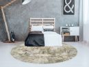 Modernes Schlafzimmer mit Doppelbett, rundem Teppich, Holzlampe, Kommode und grauer Betonwand im skandinavischen Stil.
