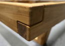 Detailaufnahme einer präzisen Holzverbindung an einer massiven Holztisch-Ecke, hochwertige Tischlerei-Arbeit.