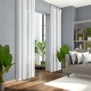 Helles Wohnzimmer mit grauer Couch, weißen Vorhängen, Holzboden, Zimmerpflanzen und modernem Regal.