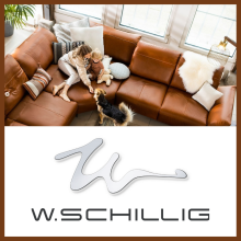 Moderne Wohnzimmerszene mit braunem Ledersofa; eine Frau sitzt mit einem Kleinkind auf dem Sofa und streichelt einen Hund; rechts das Logo von W.SCHILLIG.  