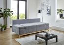 Modernes Wohnzimmer mit grauem Sofa, Couchtisch, Pflanzen, Wandbildern und großen Fenstern mit Tageslicht.
