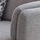 Detailaufnahme eines modernen, grauen Sofas mit strukturierter Stoffoberfläche und dekorativem Kissen.