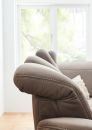 Braunes Ledersofa mit verstellbarer Kopfstütze steht vor einem großen, hellen Fenster im modernen Wohnzimmer.